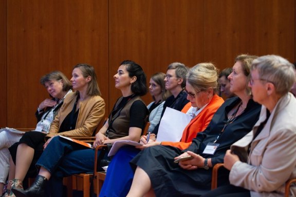 Sieben Frauen sitzen in der ersten Reihe, Blick auf die Bühne, bei der Abschlusskonferenz InnoGründerinnen 07.06.24